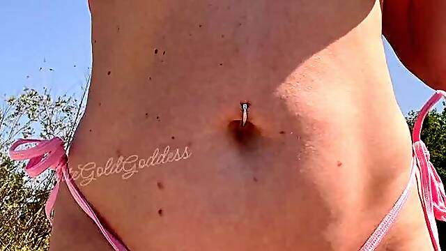 A thick MILF oiled up in a micro bikini and big ol milky boobs!